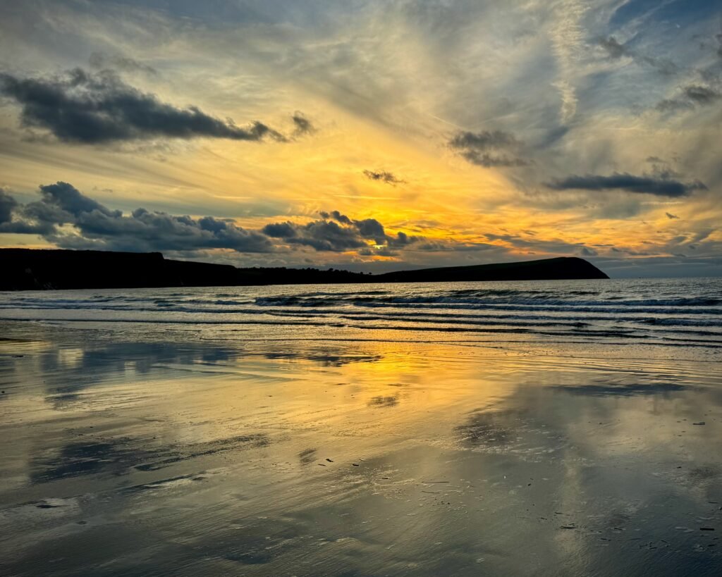 Sky drama reflected in wet sand at Newport Sands, Pembrokeshire, Wales
