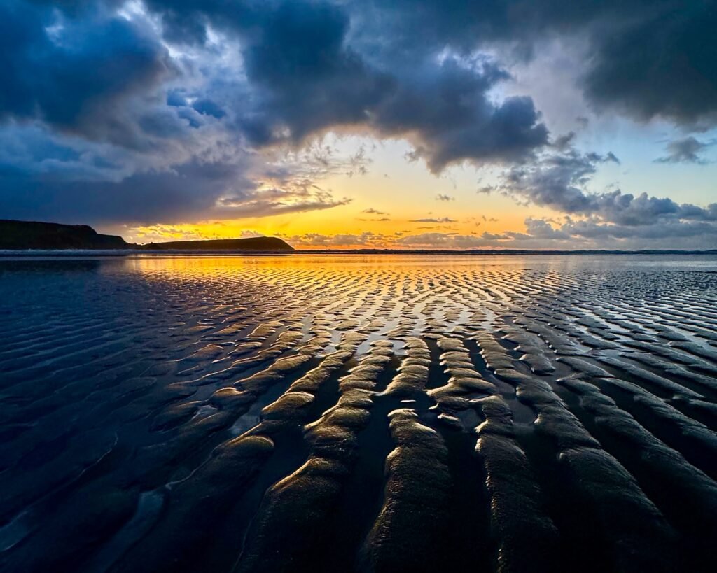 Twilight sky reflected in rippled sand at Newport Sands, Pembrokeshire, Wales