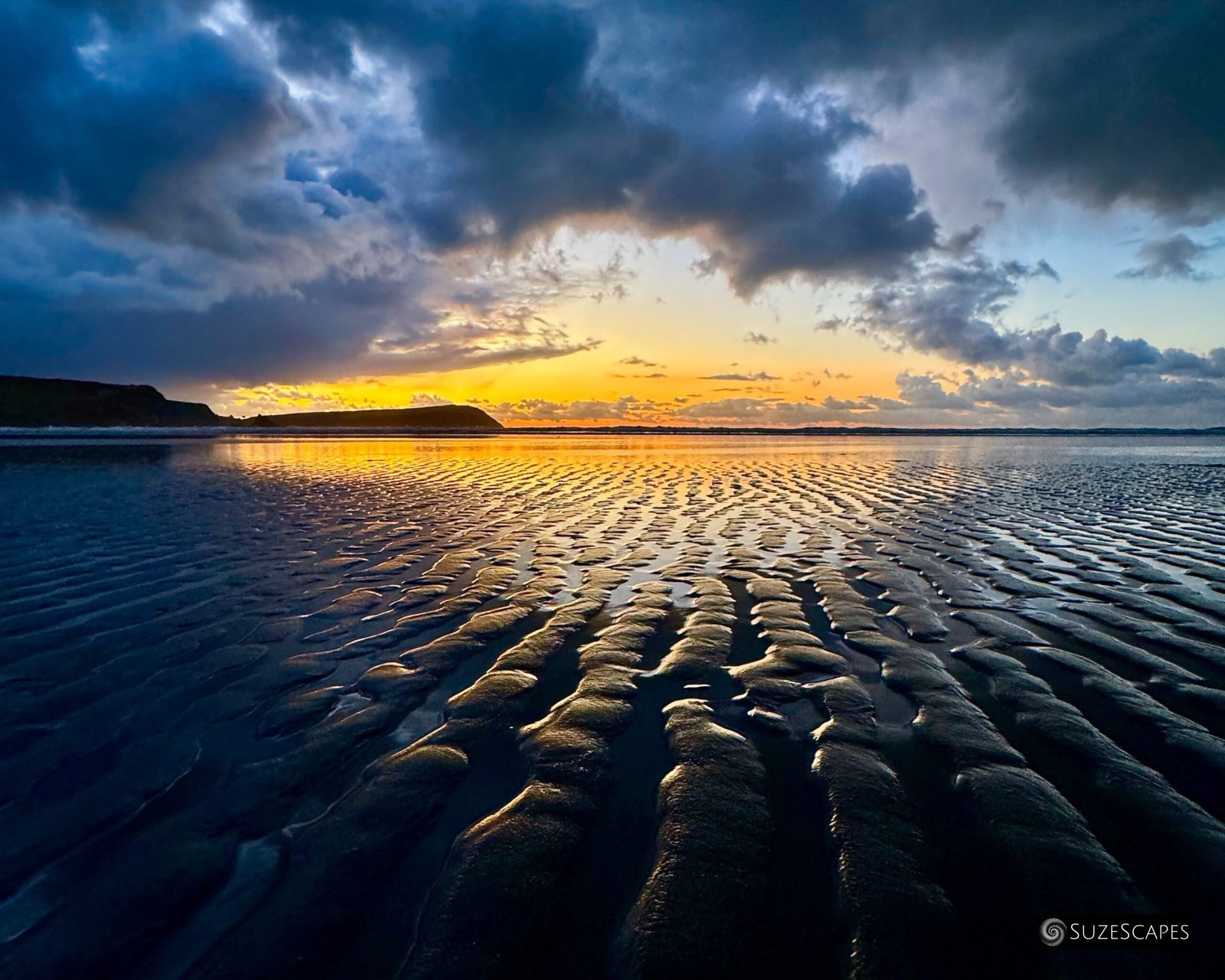 Twilight sky reflected in rippled sand at Newport Sands, Pembrokeshire, Wales
