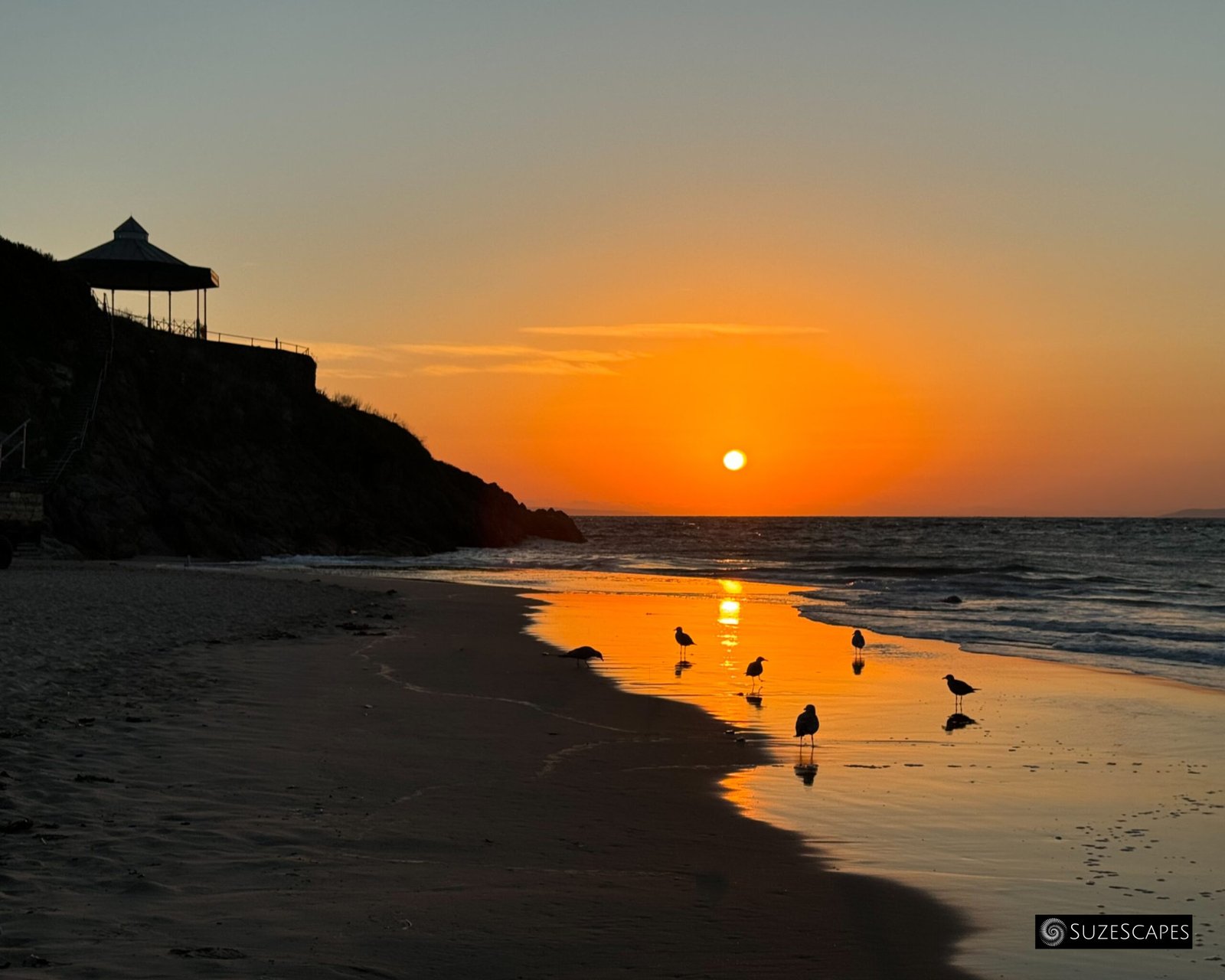 Sunrise with gulls at Castle Beach in Tenby, Pembrokeshire, Wales