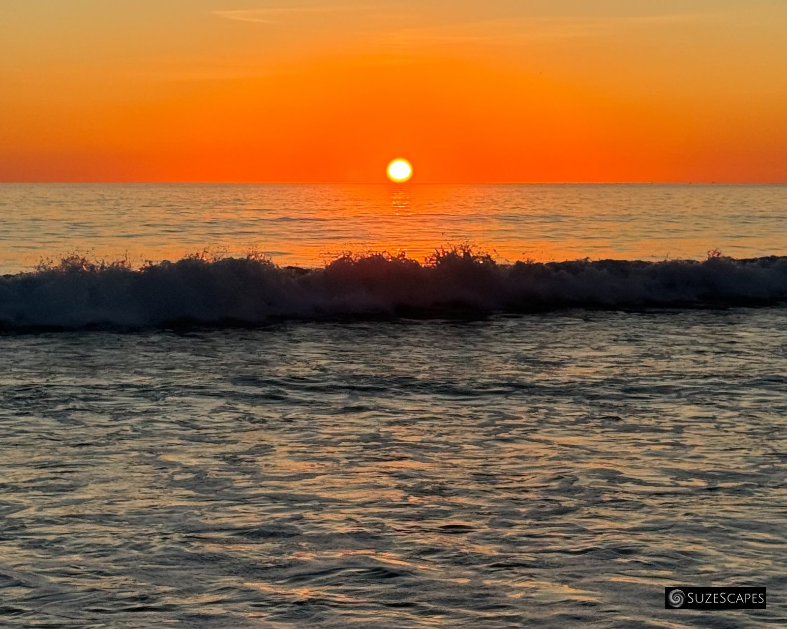Silhouetted wave at sunset at Freshwater West, Pembrokeshire, Wales