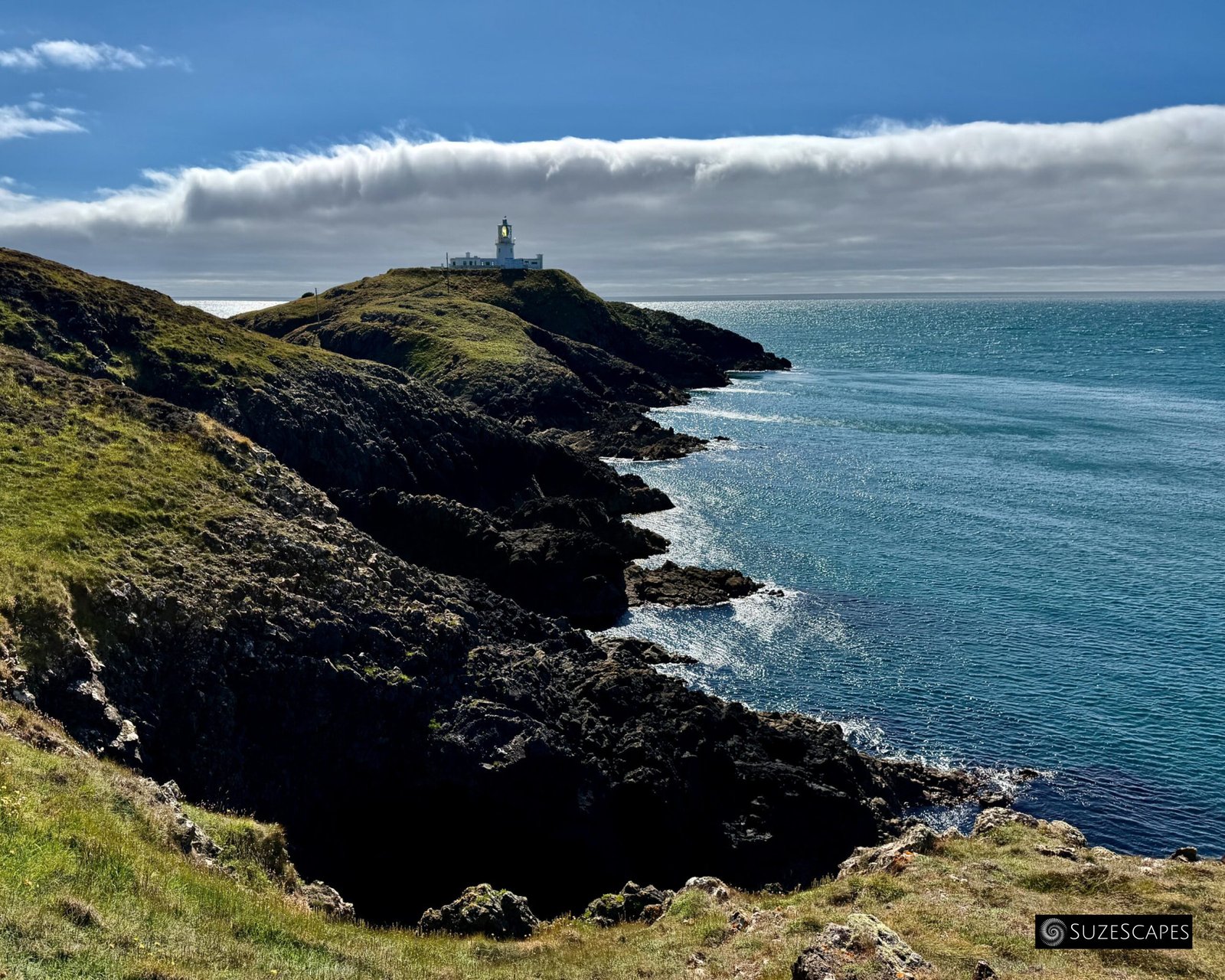 Strumble Head lighthouse silhouetted against clouds, Pembrokeshire, Wales